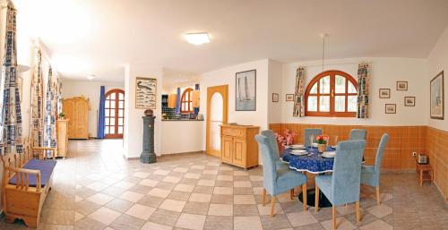 uma sala de jantar com uma mesa e cadeiras azuis em The Pearl of Balaton em Szigliget