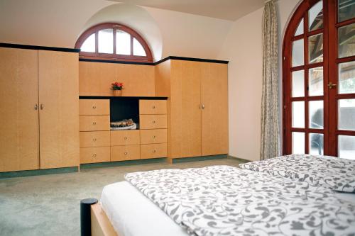 a bedroom with a bed and cabinets and a window at The Pearl of Balaton in Szigliget