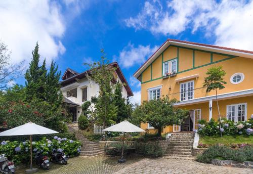 a yellow house with umbrellas in front of it at BICH DAO Boutique - Dalat in Da Lat