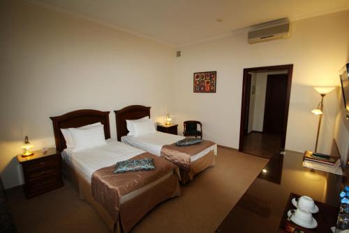 une chambre d'hôtel avec 2 lits et une table de nuit dans l'établissement Gulf Stream Hotel, à Kazan