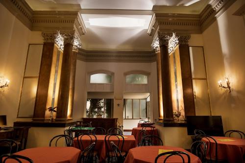a room with tables and chairs with red table cloth at Hotel Villa Delle Rose in Rome