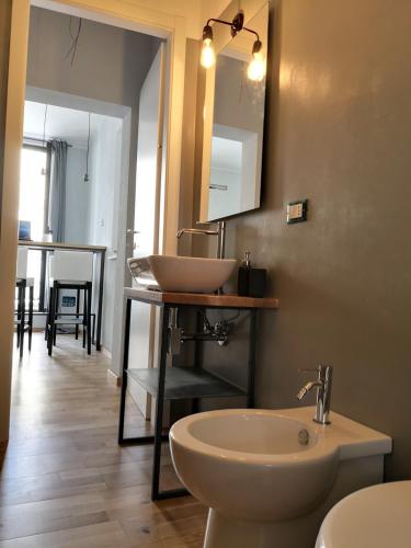 a bathroom with a sink and a toilet and a mirror at Casa Vacanze "A Machina Ro Ghiaccio" in Noto