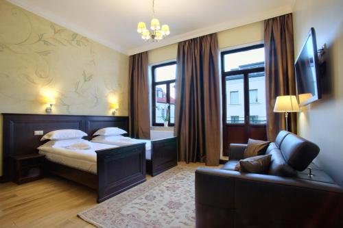 a hotel room with a bed and a couch at BoutiqueHotel Aristo in Białystok