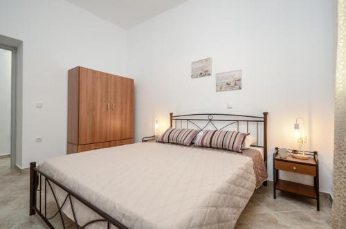 ein Schlafzimmer mit einem großen Bett und einem Holzschrank in der Unterkunft My Family Home in Glinado Naxos