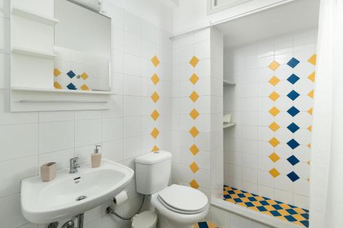 une salle de bain blanche avec toilettes et lavabo dans l'établissement Maximos Sea & The City, à Rhodes