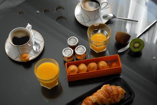 - une table avec un petit-déjeuner composé de jus d'orange et de croissants dans l'établissement The Sleeping Lion, à Paris
