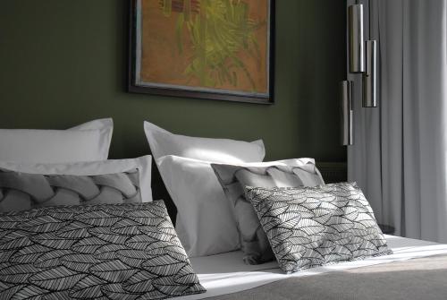 ein Schlafzimmer mit grünen Wänden und einem Bett mit Kissen in der Unterkunft The Sleeping Lion in Paris