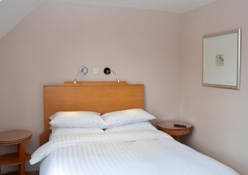 a bedroom with a bed with white sheets and pillows at The Antelope at Upavon in Upavon