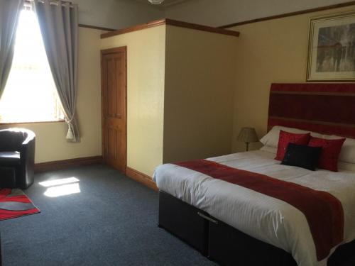 a bedroom with a bed and a dresser at Woodlands Guest House in Liverpool