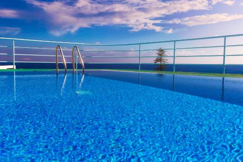 a swimming pool with two metal poles in the water at Aparthotel Imperatriz in Funchal