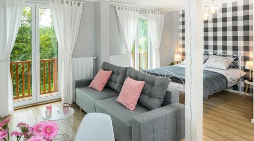 a living room with a bed and a couch and a bedroom at Apartament na Wierchu in Bukowina Tatrzańska