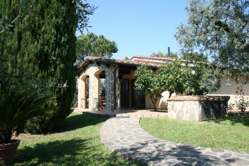 a house with a walkway in front of a yard at Casetta sulla Bolgherese immersa nel Verde in Castagneto Carducci