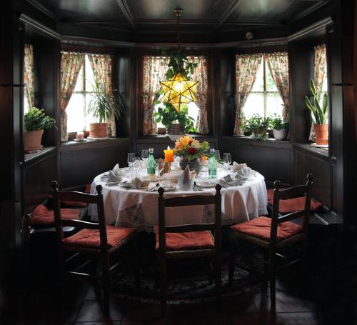 a dining room with a table and chairs and windows at Gasthof Hohlwegwirt in Hallein