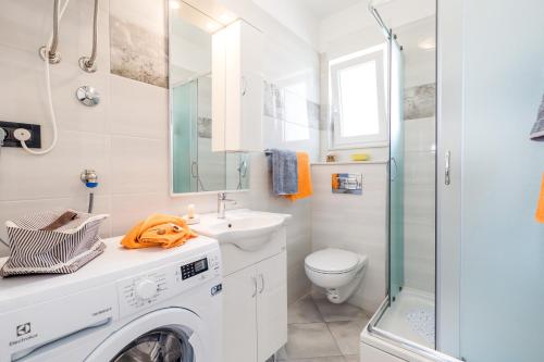 y baño blanco con lavadora. en Apartmani Hrvatin, en Opatija