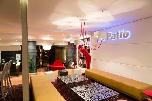 a lobby with benches and a pita sign on the wall at Hôtel de Brienne in Toulouse