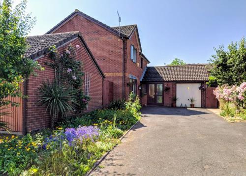 an old brick house with a driveway and flowers at Spring Meadow in Worcester