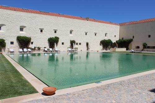 a large swimming pool in front of a building at Convento das Bernardas AZ in Tavira