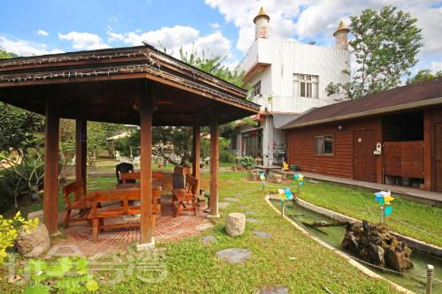 un pabellón con una mesa de picnic frente a una casa en 華山禾園親子民宿 en Gukeng