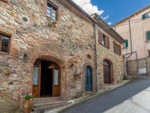 um velho edifício de tijolos com uma porta numa rua em Belvilla by OYO Il Vecchio Frantoio em Orciatico