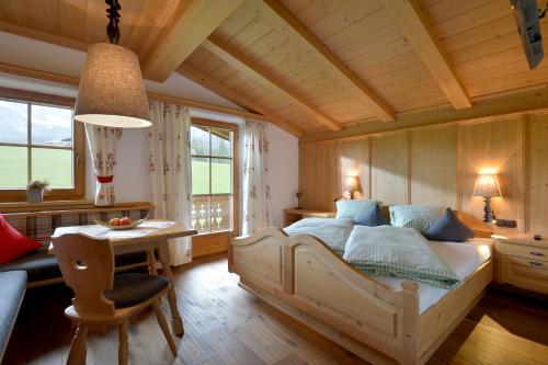 a bedroom with a bed and a table and a desk at Koasa Chalet in Going am Wilden Kaiser