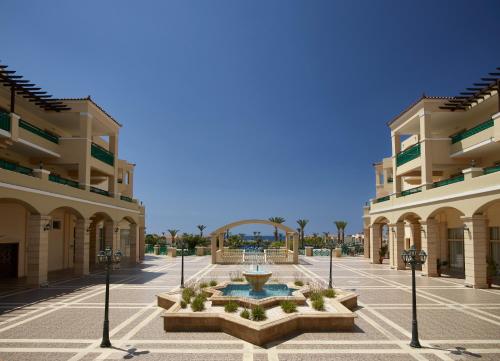 a courtyard in the middle of a building with a fountain at Lindos Princess Beach Hotel in Lardos