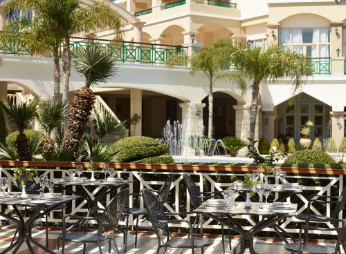 a restaurant with tables and chairs in front of a building at Lindos Princess Beach Hotel in Lardos