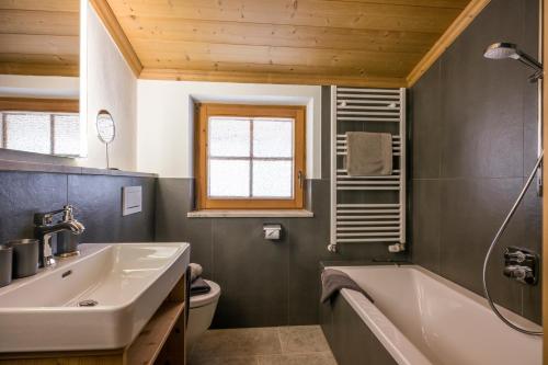 a bathroom with a white tub and a sink at Koasa Chalet in Going am Wilden Kaiser