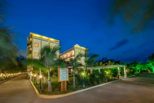 a building with a sign in front of it at night at Viceroy Beach And Spa Resort in Mandarmoni