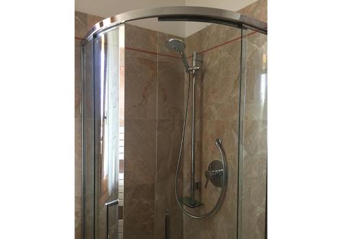a shower with a glass door in a bathroom at Appartamenti fronte mare in Castiglioncello