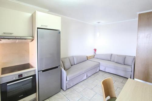 a small living room with a couch and a kitchen at Chios Xenia Studios & Apartments in Paralia Agias Foteinis