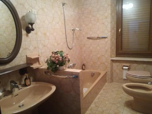 y baño con lavabo, aseo y bañera. en Spazioso appartamento indipendente, en Apecchio