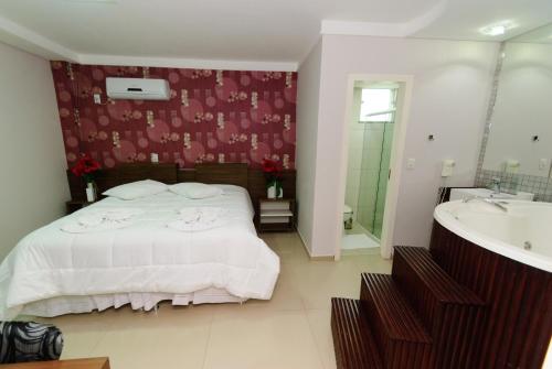 une chambre avec un lit, une baignoire et un lavabo dans l'établissement Hotel Paraiso, à Correia Pinto