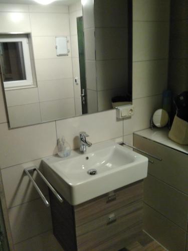a bathroom with a white sink and a mirror at Bungalow am Werratal Radwanderweg in Breitungen