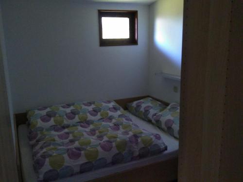 Dormitorio pequeño con cama y ventana en Bungalow am Werratal Radwanderweg, en Breitungen