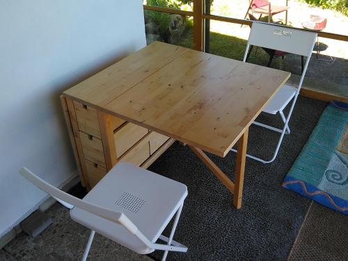 a wooden table with two chairs and a wooden desk at Bungalow am Werratal Radwanderweg in Breitungen