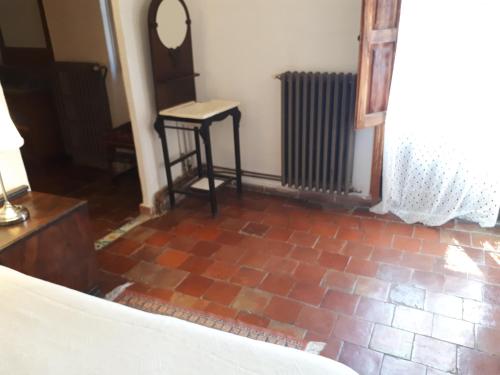 a bedroom with a red brick floor and a mirror at Fonda Del Tozal in Teruel