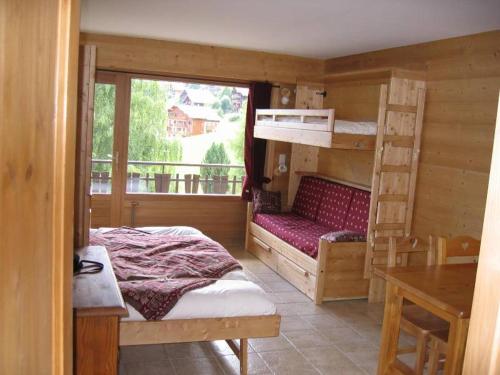 1 dormitorio con literas, escritorio y ventana en Studio Forclaz, en Le Grand-Bornand