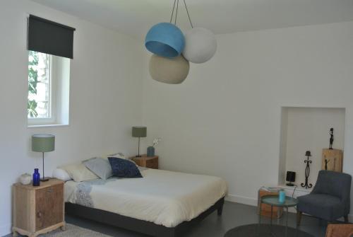 a bedroom with a bed and a blue lamp at L'Epiphanie in Tonnerre