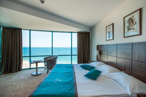 a bedroom with a large bed with a view of the ocean at Marina Grand Beach Hotel - All Inclusive Plus in Golden Sands