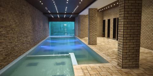 a lap pool in a room with a brick wall at Deventure Shimla Hills in Kandāghāt
