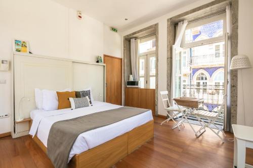een slaapkamer met een groot bed en een groot raam bij Stay in Apartments - S. Bento in Porto