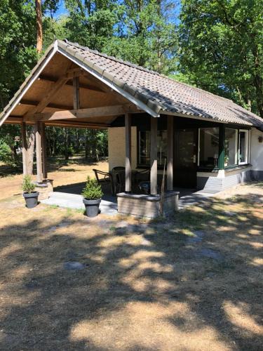 a house with a wooden roof and a patio at Vosseven 15 Haasje in Stramproy