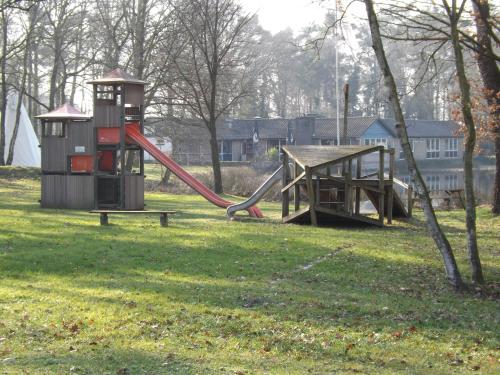 a playground with a slide in a park at Vosseven 15 Haasje in Stramproy