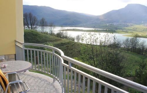 a balcony with a table and a view of a lake at Rooms & Apartment Jozić in Prozor