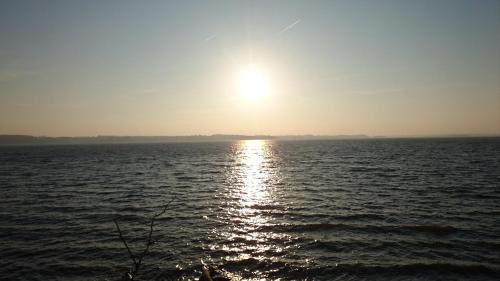 a sun setting over a large body of water at Ferienwohnung Ostsee in Karby