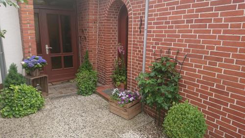 a front door of a brick house with potted plants at Ferienwohnung Ostsee in Karby