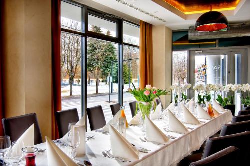 a long table with white tables and chairs in a room at BoutiqueHotel Aristo in Białystok