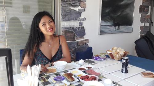 a woman sitting at a table with food at Mavi Panorama Villa in Cesme