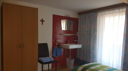 ein Badezimmer mit einem Waschbecken und einer roten Kachelwand in der Unterkunft Haus Christina in Hippach