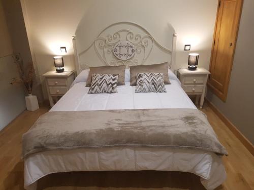 a bedroom with a large bed with two night stands at Apartamentos Santa Justa in Ubiarco